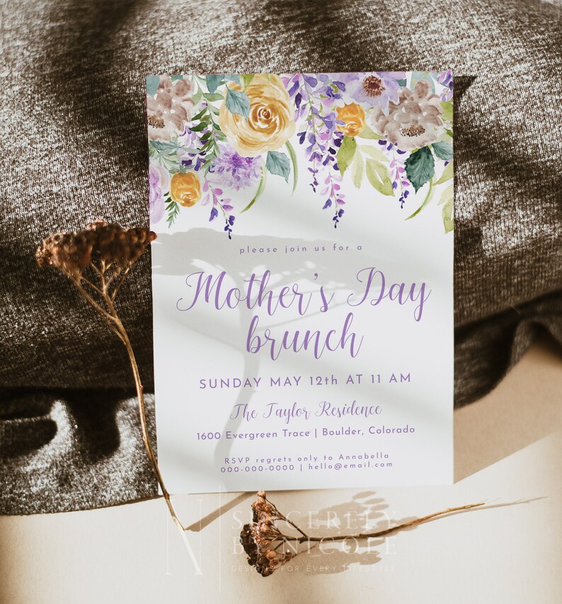 May include: A watercolor floral design invitation for a Mother's Day brunch. The invitation features a purple and yellow floral design with the text "Mother's Day brunch" in purple script. The text below reads "Sunday May 12th at 11 AM, The Taylor Residence, 1600 Evergreen Trace | Boulder, Colorado. RSVP regrets only to Annabella 000-000-0000 | hello@email.com"