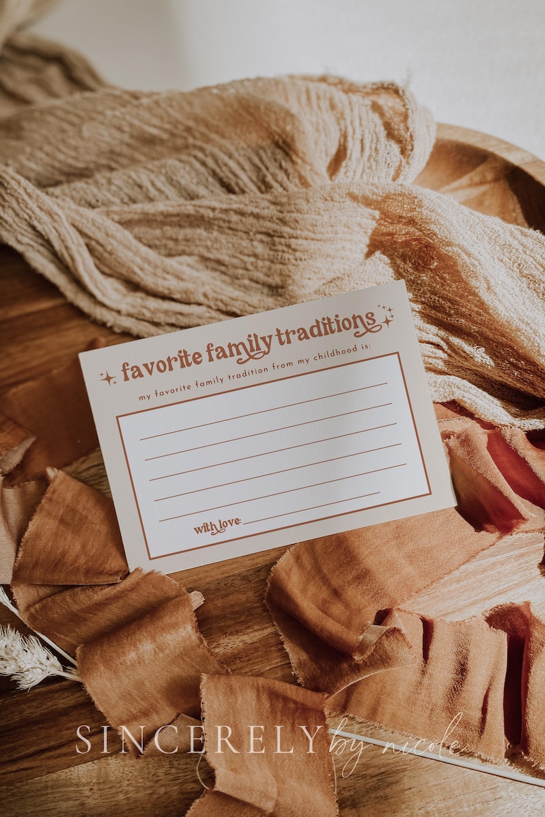 A nostalgic fill-in card placed on textured fabric with warm brown hues. Designed for capturing cherished childhood traditions, making it a beautiful addition to baby showers or seasonal celebrations.