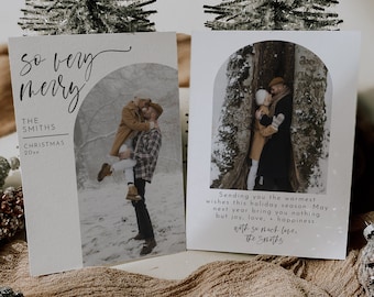 May include: A white Christmas card with a photo of a couple in a snowy forest. The card reads "so very merry" and "The Smiths Christmas 20xx".