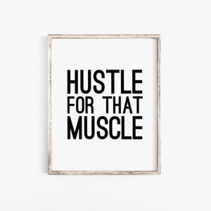 May include: A framed print with the text "Hustle for that Muscle" in black lettering on a white background.