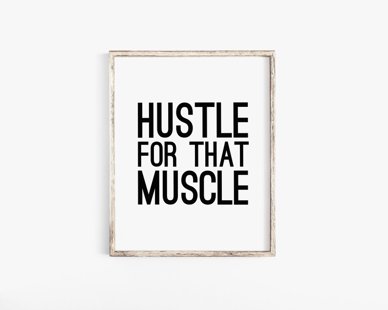May include: A framed print with the text "Hustle for that Muscle" in black lettering on a white background.
