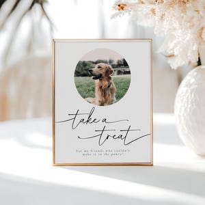 May include: A gold-framed sign with the text "take a treat" in black cursive script. The sign also includes a photo of a golden retriever dog in a circle, with the text "For my friends who couldn't make it to the party!" below the photo.