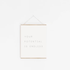Puede incluir: Una impresi&oacute;n enmarcada blanca con el texto "YOUR POTENTIAL IS ENDLESS" colgada en una pared blanca.