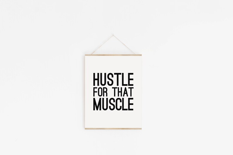 May include: A white framed motivational poster with black text that reads "Hustle for that Muscle".