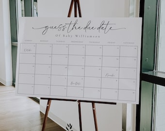 May include: A white sign with a black calendar on it. The sign says "guess the due date of baby Williamson". The calendar has the months of October and November. The due date is marked with the words "Due Date".