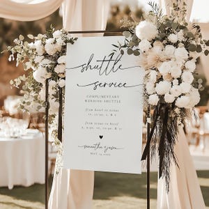 May include: White sign with black text announcing a complimentary wedding shuttle service. The sign lists shuttle times from the hotel to the venue and from the venue to the hotel. The sign also includes the names Samantha and Jason and the date May 13, 2023.