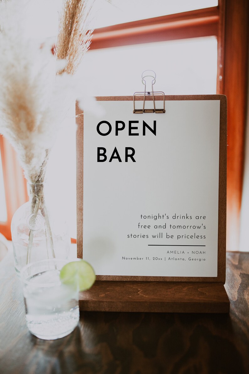 Puede incluir: Un cartel blanco con texto negro que dice "OPEN BAR" y "tonight's drinks are free and tomorrow's stories will be priceless." El cartel tambi&eacute;n incluye los nombres Amelia y Noah, la fecha 11 de noviembre de 20xx y la ubicaci&oacute;n Atlanta, Georgia.
