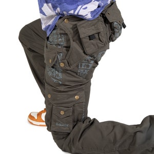 Pantalones cargo psicodélicos oliva con cinturón de bolsillo desmontable y estampado maya. Pantalones tecnológicos holgados cyberpunk para hombre. Ropa para el festival Burning Man.