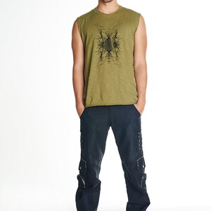 May include: A man is wearing a green sleeveless shirt with a black graphic print and black cargo pants.