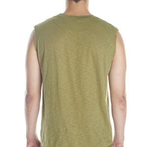 May include: A sleeveless shirt in a light green color with a textured fabric. The shirt has a crew neck and a relaxed fit.