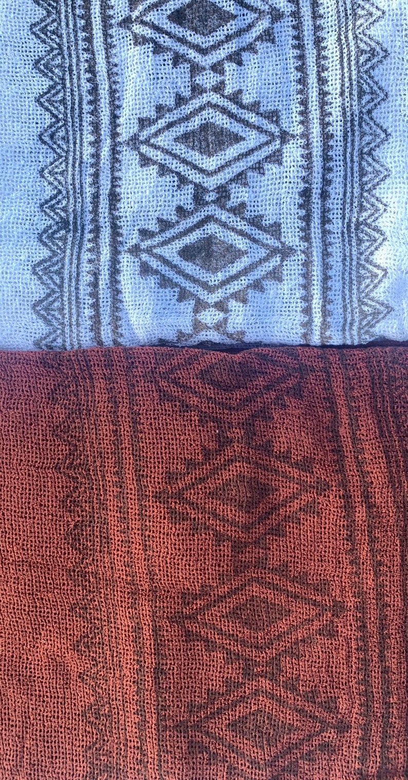May include: Two pieces of fabric with a geometric pattern. The top piece is light blue with a dark gray pattern. The bottom piece is a dark red with a dark gray pattern.
