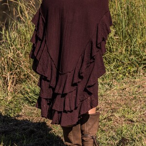 May include: A maroon skirt with multiple layers of ruffles. The skirt is made of a soft, flowing fabric and has a casual, bohemian style.