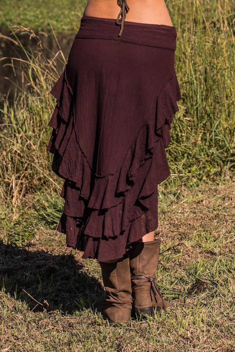 May include: A maroon skirt with multiple layers of ruffles. The skirt is made of a soft, flowing fabric and has a casual, bohemian style.