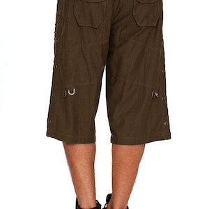 May include: Dark green cargo shorts with multiple pockets and metal accents. The shorts have a black belt with metal eyelets.