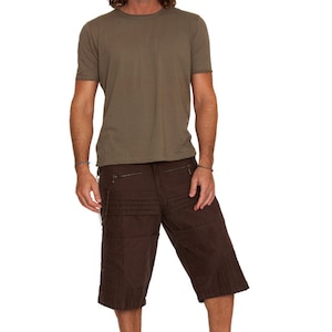 May include: A man is wearing a brown t-shirt and brown cargo shorts with multiple pockets. He is wearing black high-top sneakers.