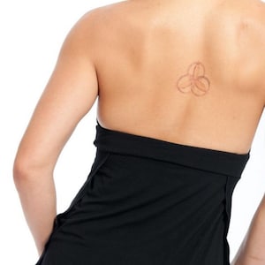 May include: Black halter top with a low back and a thin strap. The top is made of a soft, stretchy fabric and has a relaxed fit.