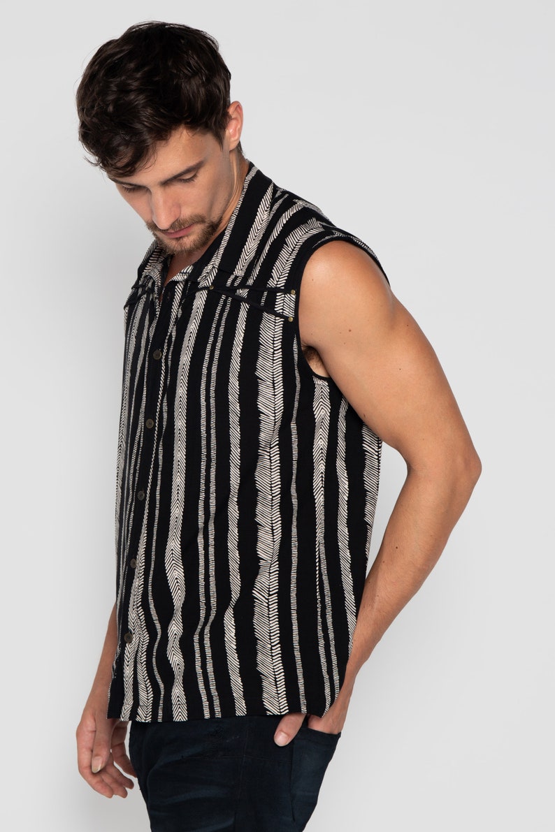 May include: A sleeveless button-up shirt with a black and white striped pattern. The shirt has a collar and a button closure.