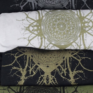 May include: Four folded t-shirts with a geometric pattern and a tree-like design in black, white, and green.