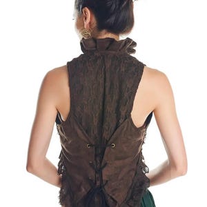 May include: A sleeveless brown waistcoat featuring a high ruffled collar and a lace overlay. The back of the garment includes a corset-style lace-up closure with black cord threaded through metal eyelets, creating a fitted silhouette with ruffled edges.