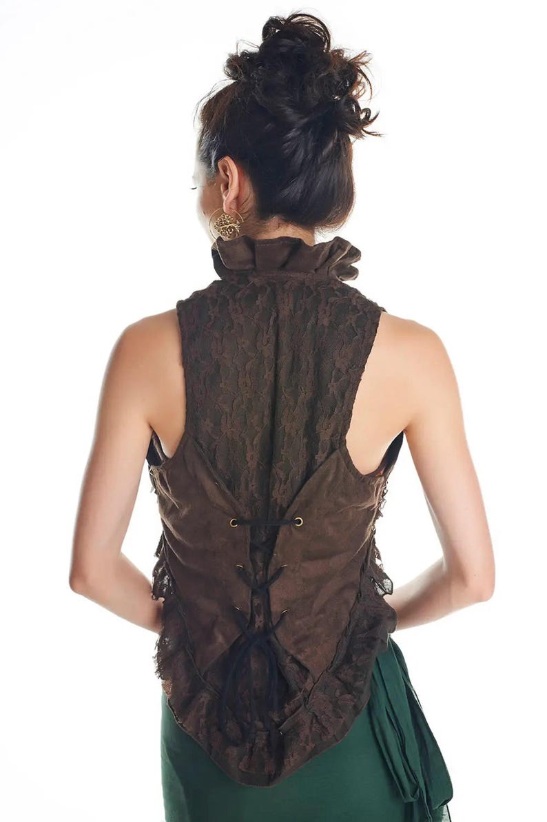 May include: A sleeveless brown waistcoat featuring a high ruffled collar and a lace overlay. The back of the garment includes a corset-style lace-up closure with black cord threaded through metal eyelets, creating a fitted silhouette with ruffled edges.
