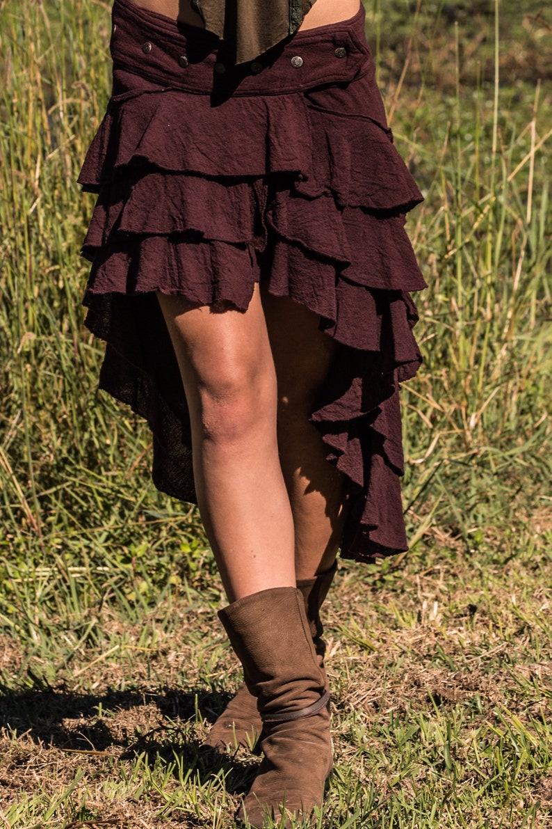 May include: A burgundy tiered skirt with a high-low hemline. The skirt is made of a soft, flowing fabric and has a casual, bohemian style.