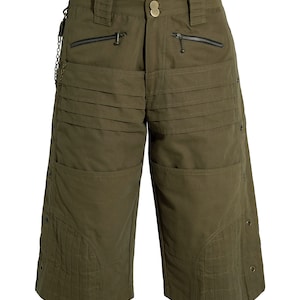 May include: Olive green cargo shorts with multiple pockets and a chain detail. The shorts have a button and zipper closure.
