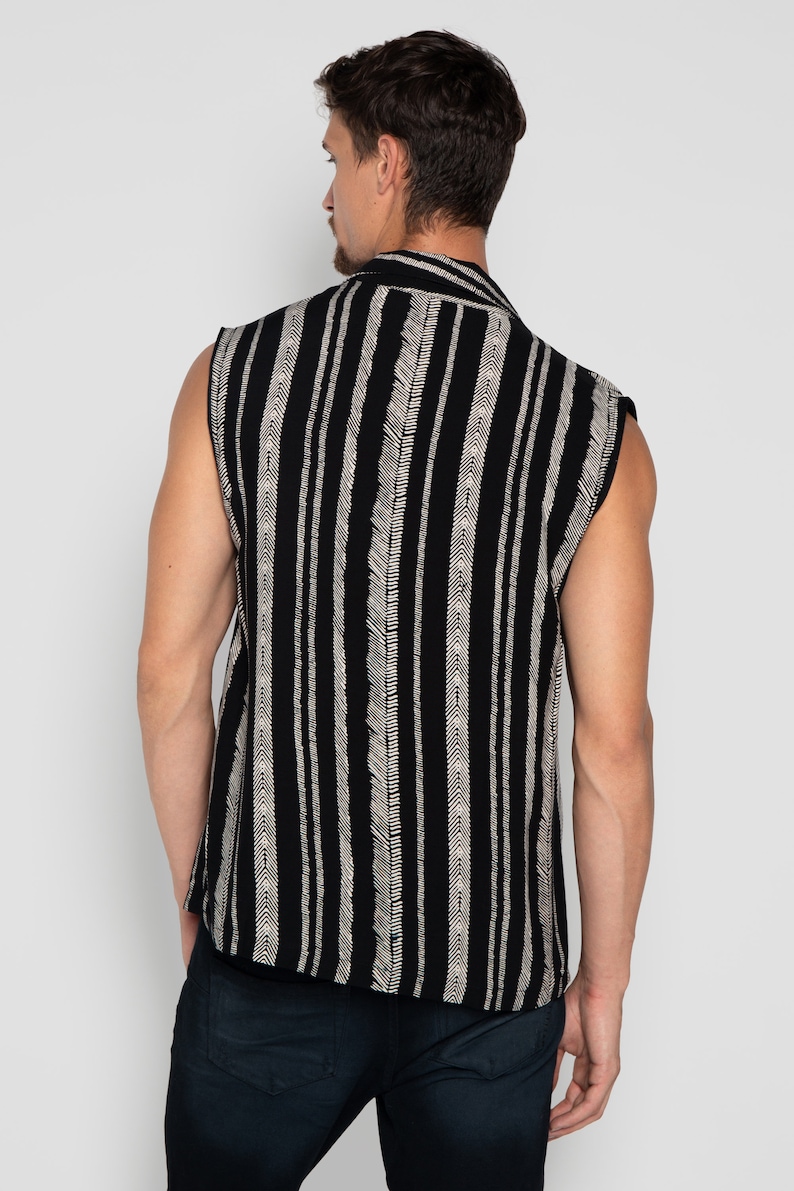 May include: A sleeveless shirt with a black and white striped pattern. The shirt has a button-up collar and a relaxed fit.
