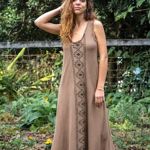 May include: A brown sleeveless maxi dress with a geometric pattern in black. The dress has a relaxed fit and a frayed hem.