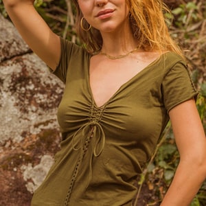 May include: A green, short-sleeved, v-neck top with a lace-up detail in the front. The top is made of a soft, comfortable fabric and has a relaxed fit.