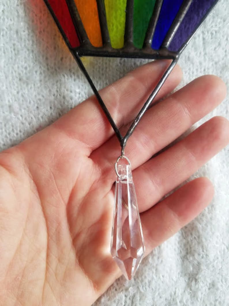 May include: A rainbow stained glass suncatcher with a clear crystal prism hanging from the bottom.
