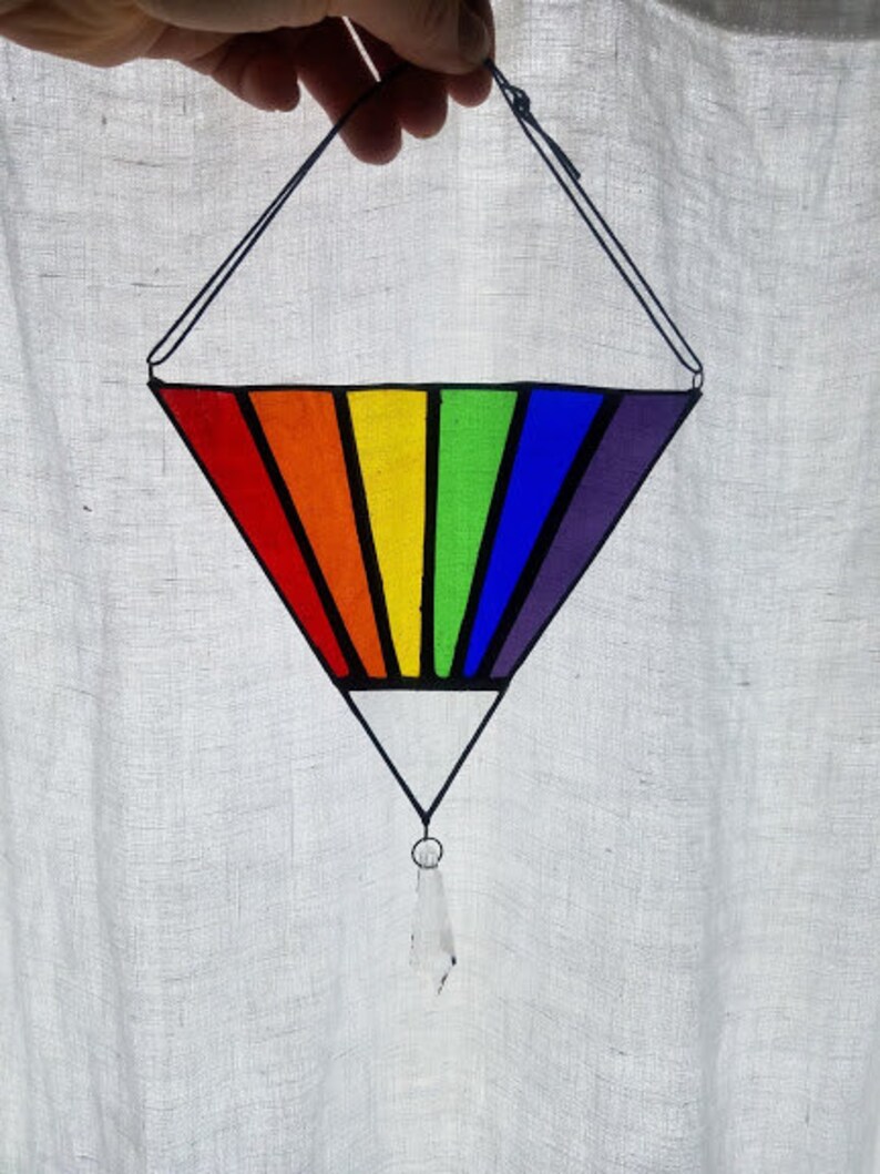May include: A rainbow stained glass suncatcher in the shape of a diamond with a crystal prism hanging from the bottom.