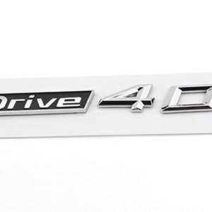 Könnte beinhalten: Silbernes und schwarzes Autoemblem mit dem Text "xDrive 40d".