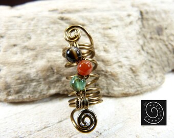 May include: A gold wire ear cuff with three beads: a black and white agate, a red carnelian, and a green aventurine.