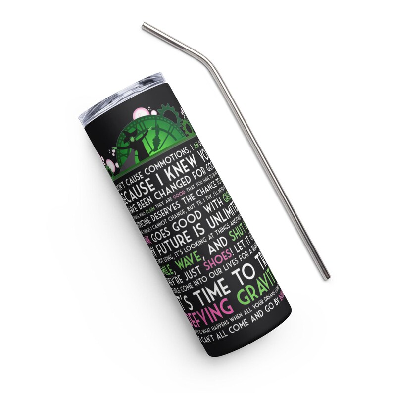 Op de afbeelding: Zwarte beker met een zilveren rietje. De beker heeft een groen en zwart ontwerp met witte en roze tekst. De tekst bevat zinnen als "Defying Gravity" en "Future is Unlimited".