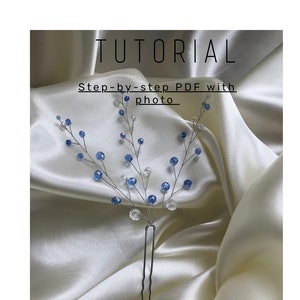 May include: A decorative hair pin with a floral design. The pin has a silver wire base decorated with blue and clear crystal beads. The word "TUTORIAL" is at the top, with "Step-by-step PDF with photo" below.