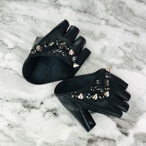 May include: A pair of black fingerless gloves with silver studs and rhinestones.
