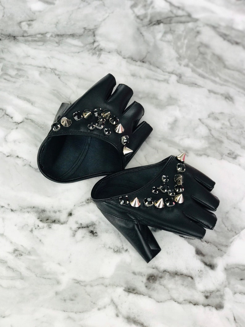 May include: A pair of black fingerless gloves with silver studs and rhinestones.