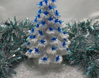 Árbol de Navidad de cerámica, pequeños pájaros blancos y azules, brillo dorado y nieve helada