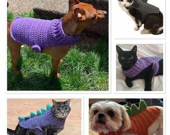 May include: A collection of four crocheted pet sweaters in different colors and styles. The sweaters feature a variety of designs, including a purple dinosaur, a gray shark, and a green and orange pumpkin. The sweaters are all made with soft yarn and are perfect for keeping pets warm and cozy.
