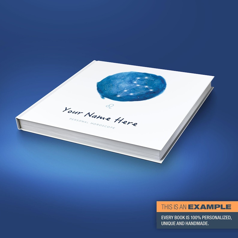 May include: A white book with a blue watercolour illustration of the Leo constellation. The book has the text "Your Name Here" and "Personal Horoscope" printed on the cover.