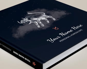 May include: A square hardcover book with a dark navy blue cover featuring a white line-art illustration of a bull, a small red Taurus zodiac symbol, and the text "Your Name Here" followed by "PERSONAL HOROSCOPE" in white script and print.