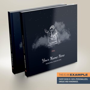 May include: A dark blue personalised horoscope book with a white illustration of the Aquarius zodiac sign. The book has the text "Your Name Here" and "Personal Horoscope" printed on the cover.