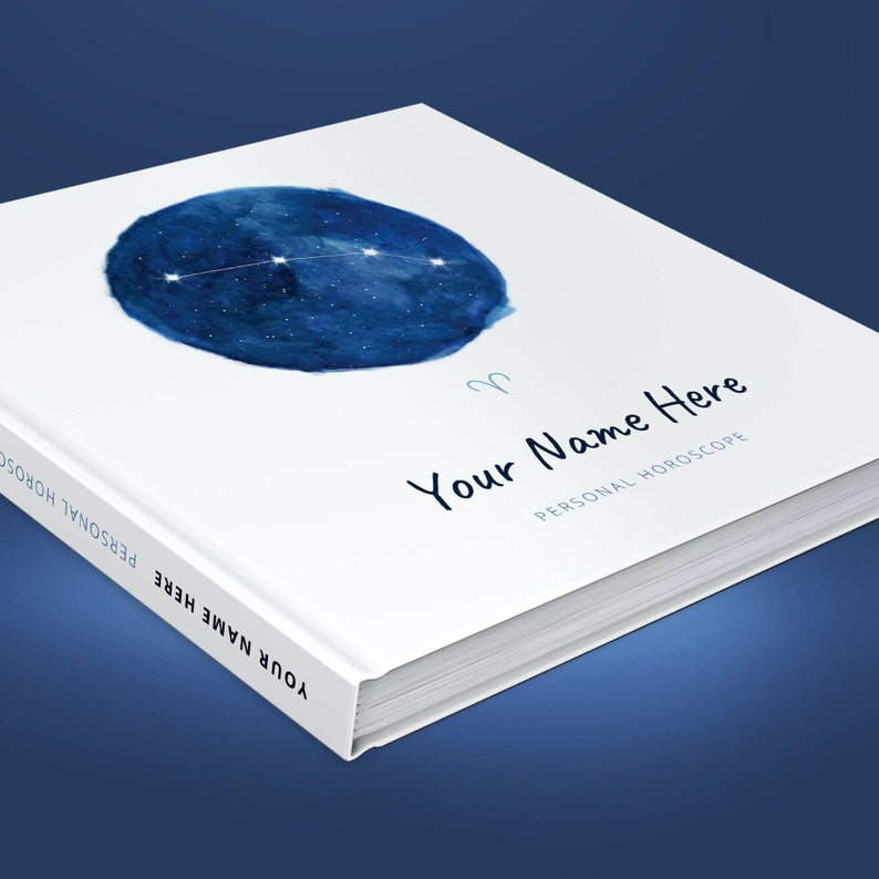 May include: A white book with a blue watercolour illustration of the Aries constellation. The book has the text "Your Name Here" and "Personal Horoscope" on the cover.