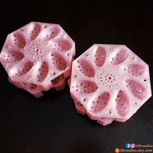 Może przedstawiać: Dwa różowe plastikowe formy z kwiatowym wzorem. Każda forma ma osiem owalnych wnęk. Formy są ułożone jedna na drugiej.