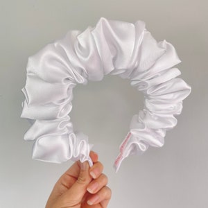 May include: White satin scrunchie with a pink label that says "Handmade with Love".