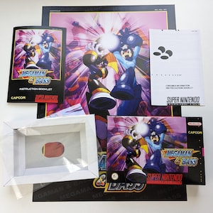 May include: A Super Nintendo game cartridge for Mega Man & Bass. The box is black with a purple and blue background image of Mega Man and Bass fighting. The game title is in white text. The box is next to a white instruction booklet with a blue and black image of Mega Man and Bass.