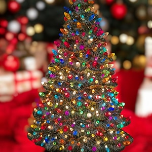 Può includere: Un albero di Natale in ceramica verde scuro, adornato con numerose luci colorate. L'albero è illuminato con una varietà di colori di lampadine, tra cui rosso, blu, giallo e verde. Poggia su una base nera.