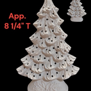 Könnte beinhalten: Ein weißer Keramik-Weihnachtsbaum mit strukturierter Oberfläche und kleinen Löchern für Lichter. Der Baum ist etwa 21 cm hoch und steht auf einem dekorativen Sockel. Eine kleinere Version des Baumes ist ebenfalls sichtbar.