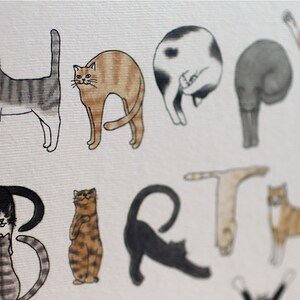 May include: A greeting card with the word "HAPPY" spelled out using illustrations of cats in various poses. The word "BIRTH" is spelled out using cats in different poses. The card is white with a subtle texture.