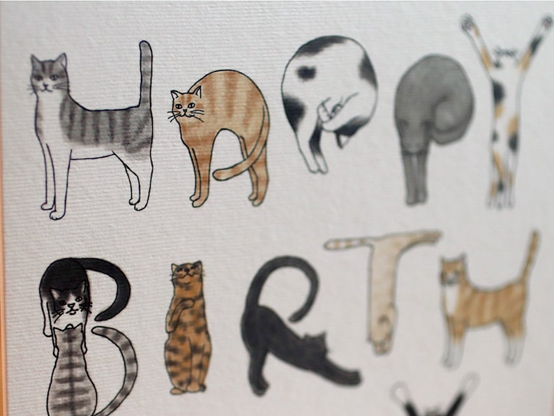 May include: A greeting card with the word "HAPPY" spelled out using illustrations of cats in various poses. The word "BIRTH" is spelled out using cats in different poses. The card is white with a subtle texture.